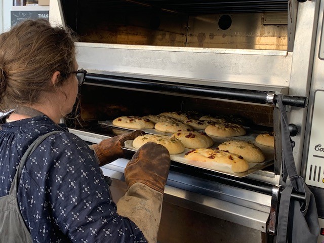 A woman bakes bread in an oven