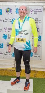 Ashley Horsey, fundraiser for Sussex Beacon in his running gear and hi vis vest for Brighton Half Marathon.